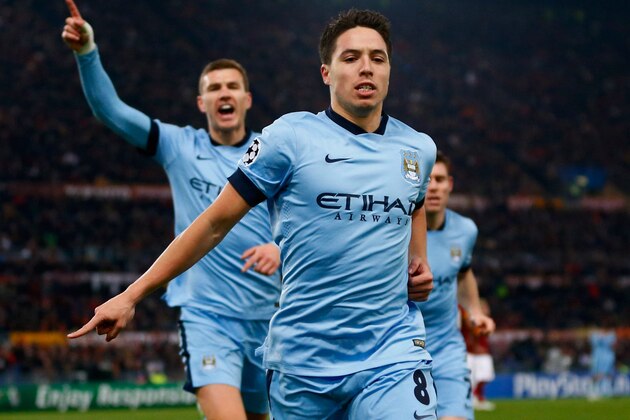 ROME, ITALY - DECEMBER 10:  Samir Nasri of Manchester City (front) celebrates with Edin Dzeko (L) as he scores their first goal during the UEFA Champions League Group E match between AS Roma and Manchester City FC at Stadio Olimpico on December 10, 2014 in Rome, Italy.  (Photo by Julian Finney/Getty Images)