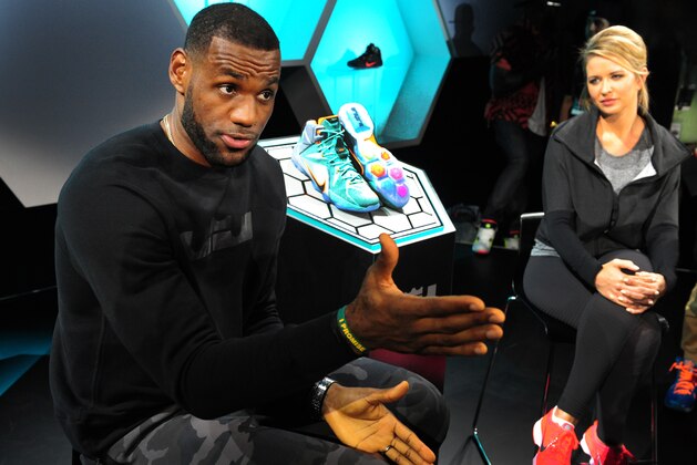 LeBron James, answers a question from members of the media as Kristen Ledlow looks on during the introduction of the LeBron 12 shoe at the Nike World Headquarters in Beaverton, Ore., on Tuesday, Sept. 16, 2014. (AP Photo/Steve Dykes)