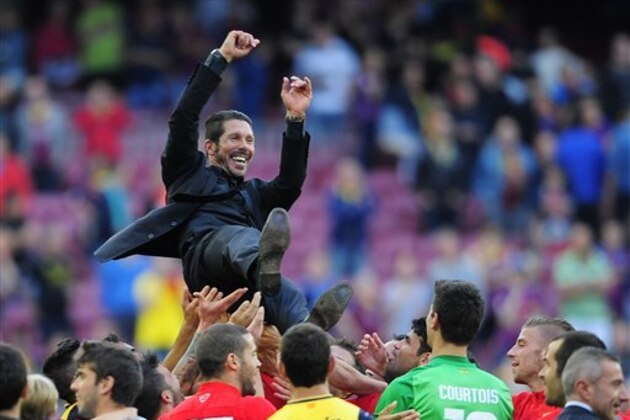 Players throw in the air Atletico's coach Diego Simeone from Argentina after a Spanish La Liga soccer match between FC Barcelona and Atletico Madrid at the Camp Nou stadium in Barcelona, Spain, Saturday, May 17, 2014. Atletico clinched its first league title in 18 years after a 1-1 draw. (AP Photo/Manu Fernandez)