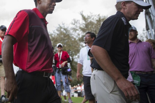 Tiger Woods, center, and Steve Stricker walk off the 18th green after they finish there final round of the Hero World Challenge golf tournament on Sunday, Dec. 7, 2014, in Windermere, Fla. (AP Photo/Willie J. Allen Jr.)