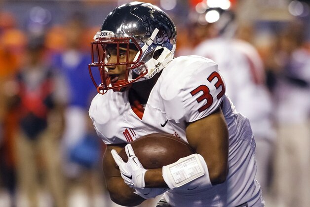 Fresno State running back Marteze Waller cradles the ball during the first half of an NCAA college football game against Boise State in Boise, Idaho, on Friday, Oct. 17, 2014. (AP Photo/Otto Kitsinger)