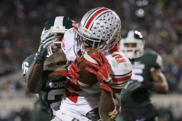 Ohio State running back Dontre Wilson, defended by Michigan State safety RJ Williamson (26) scores on a 7-yard reception during the second half of an NCAA college football game in East Lansing, Mich., Saturday, Nov. 8, 2014. (AP Photo/Carlos Osorio)