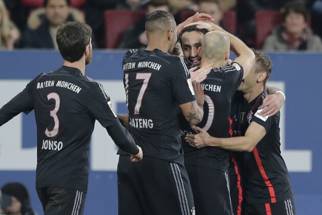Bayern’s Mehdi Benatia from Morocco, center, celebrates after scoring his side's opening goal during the German first division Bundesliga soccer match between FC Augsburg and FC Bayern Munich in the SGL Arena in Augsburg, Germany, on Saturday, Dec. 13, 2014. (AP Photo/Matthias Schrader)