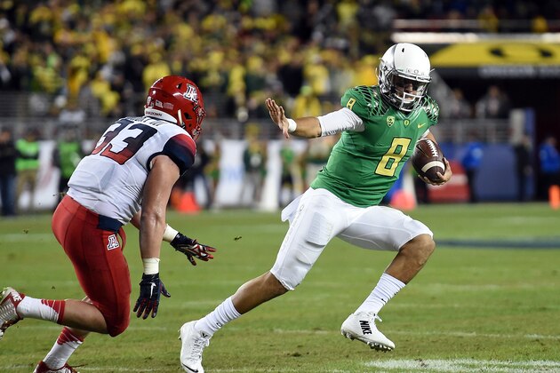 SANTA CLARA, CA - DECEMBER 05:  Marcus Mariota #8 of the Oregon Ducks tries to avoid the tackle of Scooby Wright III #33 of the Arizona Wildcats in the first half during the PAC-12 Championships at Levi's Stadium on December 5, 2014 in Santa Clara, California.  (Photo by Thearon W. Henderson/Getty Images)