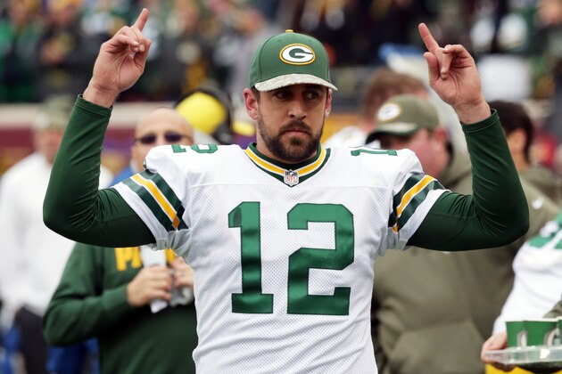 Green Bay Packers quarterback Aaron Rodgers signals touchdown as officials review one during the second half of an NFL football game against the Minnesota Vikings, Sunday, Nov. 23, 2014, in Minneapolis. (AP Photo/Jim Mone)