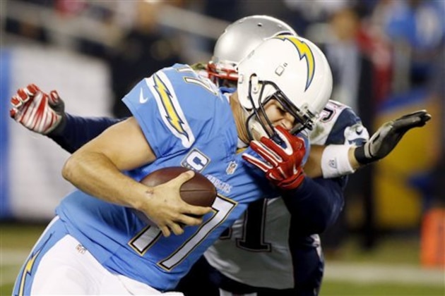 San Diego Chargers quarterback Philip Rivers fends off New England Patriots outside linebacker Jamie Collins during the first half in an NFL football game Sunday, Dec. 7, 2014, in San Diego. (AP Photo/Lenny Ignelzi)
