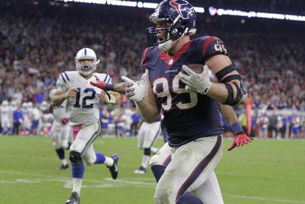 J.J. Watt (99), de los Texans de Houston, es perseguido por Andrew Luck (12), de los Colts de Indianapolis, mientras se encamina a anotar un touchdown de 45 yardas durante un partido de la NFL, el jueves 9 de octubre de 2014, en Houston. Los Texans ganaron 33-28. (AP Foto/Patric Schneider)