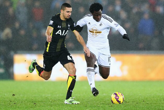SWANSEA, WALES - DECEMBER 14:  Wilfried Bony of Swansea City takes on Nabil Bentaleb of Tottenham Hotspur during the Barclays Premier League match between Swansea City and Tottenham Hotspur at Liberty Stadium on December 14, 2014 in Swansea, Wales.  (Photo by Michael Steele/Getty Images)