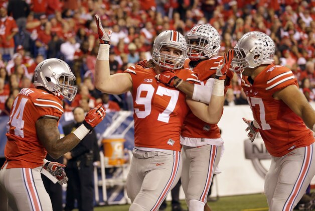 Ohio State defensive lineman Joey Bosa (97) is congratulated by teammates after recovering a fumble and running it back for a touchdown during the first half of the Big Ten Conference championship NCAA college football game against Wisconsin Saturday, Dec. 6, 2014, in Indianapolis. (AP Photo/Michael Conroy)