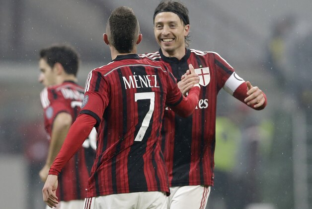 AC Milan's Jeremy Menez, back to the camera, celebrates with his teammate Riccardo Montolivo after scoring during a Serie A soccer match between AC Milan and Napoli at the San Siro stadium in Milan, Italy, Sunday, Dec. 14, 2014. (AP Photo/Antonio Calanni)