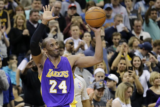 Los Angeles Lakers guard Kobe Bryant (24) holds up the game ball and acknowledges the crowd during the second quarter of an NBA basketball game against the Minnesota Timberwolves after passing Michael Jordan on the NBA all-time scoring list in Minneapolis, Sunday, Dec. 14, 2014. (AP Photo/Ann Heisenfelt)