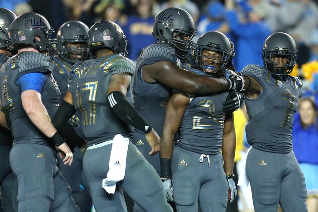 PASADENA, CA - NOVEMBER 01:  Running back Paul Perkins #24 of the UCLA Bruins is mobbed by teammates after scoring on a five yard touchdown run in the third quarter against the Arizona Wildcats at the Rose Bowl on November 1, 2014 in Pasadena, California.  UCLA won 17-7.  (Photo by Stephen Dunn/Getty Images)