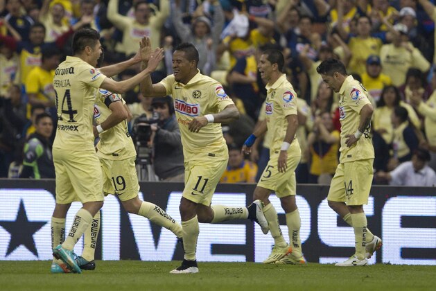 America's Michael Arroyo, center, celebrates with his teammates after scoring against Tigres during the final of the Mexican soccer league in Mexico City, Sunday, Dec. 14, 2014. (AP Photo/Christian Palma)