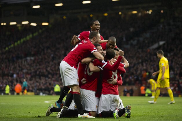Manchester United's Robin van Persie, lower centre left, celebrates with teammates after scoring during the English Premier League soccer match between Manchester United and Liverpool at Old Trafford Stadium, Manchester, England, Sunday Dec. 14, 2014. (AP Photo/Jon Super)