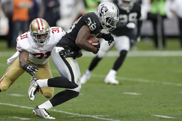 Oakland Raiders cornerback T.J. Carrie (38) is tackled by San Francisco 49ers defensive back L.J. McCray (31) during the second quarter of an NFL football game in Oakland, Calif., Sunday, Dec. 7, 2014. (AP Photo/Ben Margot)