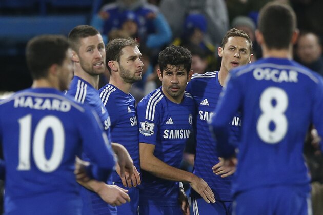 Chelsea's Diego Costa, centre, is mobbed by his teammates after scoring his sides second goal during their English Premier League soccer match between Chelsea and Hull City at Stamford Bridge stadium in London, Saturday, Dec 13, 2014. (AP Photo/Alastair Grant)