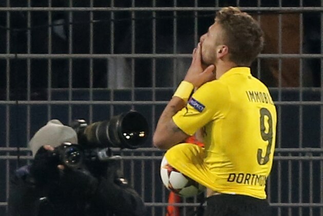 Dortmund's Ciro Immobile holds the ball under his shirt as he celebrates scoring 1-0 during the Group D Champions League soccer match between Dortmund and Anderlecht in Dortmund, Germany, Tuesday Dec. 9, 2014. (AP Photo/Frank Augstein)