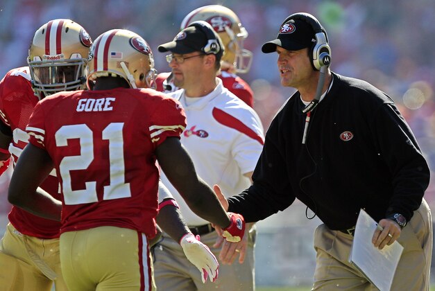 San Francisco 49ers coach Jim Harbaugh congratulates running back Frank Gore (21) after he scored a touchdown in the first quarter of an NFL football game against the Cleveland Browns in San Francisco, Sunday, Oct. 30, 2011. (AP Photo/Marcio Jose Sanchez)