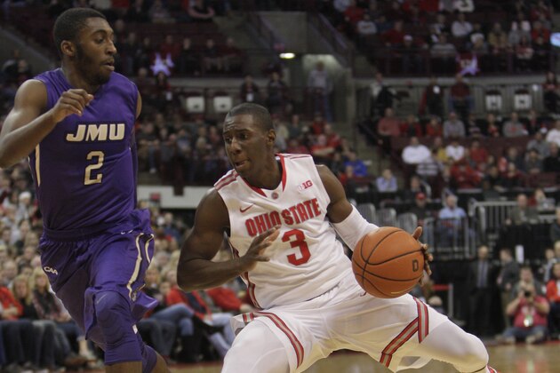 Ohio State's Shannon Scott, right, drives to the basket against James Madison's Ron Curry during the first half of an NCAA college basketball game Friday, Nov. 28, 2014, in Columbus, Ohio. (AP Photo/Jay LaPrete)