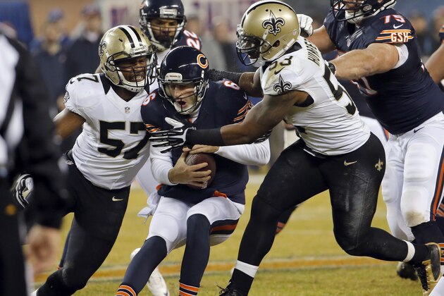 Chicago Bears quarterback Jay Cutler (6) is sacked by New Orleans Saints inside linebackers David Hawthorne (57) and Ramon Humber (53) during the first half of an NFL football game Monday, Dec. 15, 2014, in Chicago. (AP Photo/Charles Rex Arbogast)