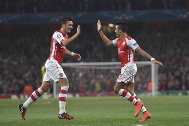 Arsenal's Alexis Sanchez, right, celebrates after scoring against Galatasaray with his teammate Mesut Ozil during the Champions League Group D soccer match between Arsenal  and Galatasaray , at the Emirates Stadium in London, on Wednesday, Oct 1, 2014. (AP Photo/ Tim Ireland)
