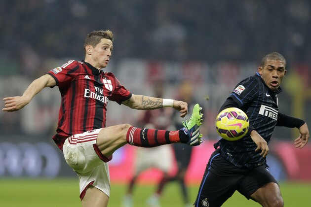 AC Milan's Fernando Torres, left, controls the ball as Inter Milan's Juan Jesus tries to stop him during the Serie A soccer match between AC Milan and Inter Milan at the San Siro stadium in Milan, Italy, Sunday, Nov. 23, 2014. (AP Photo/Antonio Calanni)