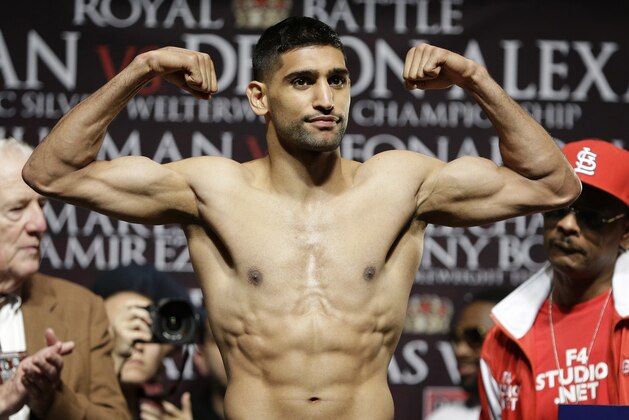 Amir Khan poses on the scale during a weigh-in Friday, Dec. 12, 2014, in Las Vegas. Khan is scheduled to fight Devon Alexander in a welterweight bout Saturday in Las Vegas.(AP Photo/John Locher)