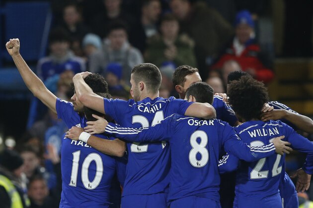 Chelsea's Diego Costa, left,  is mobbed by his teammates after scoring his sides second goal during their English Premier League soccer match between Chelsea and Hull City at Stamford Bridge stadium in London, Saturday, Dec 13, 2014. (AP Photo/Alastair Grant)