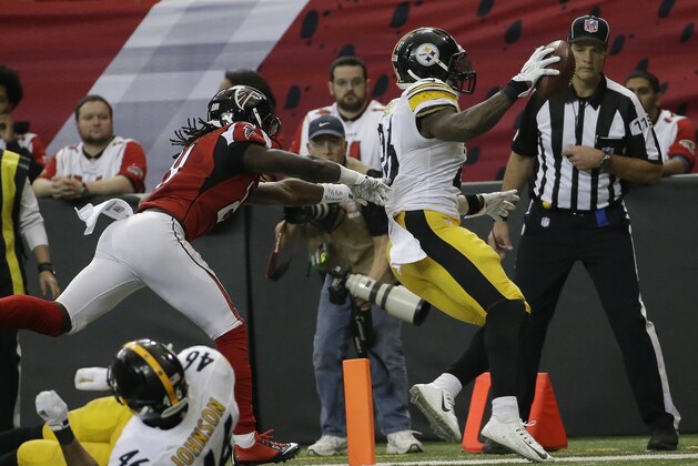 Pittsburgh Steelers running back Le'Veon Bell (26) scores a touchdown against Atlanta Falcons wide receiver Julio Jones (11) during the second half of an NFL football game, Sunday, Dec. 14, 2014, in Atlanta. (AP Photo/David Goldman)