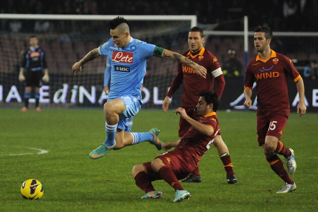 Napoli's Marek Hamsik, of Slovakia, left, is tackled by AS Roma defender Ivan Piris as Francesco Totti and Mattia Destro, right, watch, during a Serie A soccer match at the Naples San Paolo stadium, Sunday, Jan. 6, 2013. (AP Photo/Salvatore Laporta)