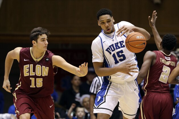 Duke's Jahlil Okafor (15) grabs the ball as Elon's Tony Sabato (15) and Dmitri Thompson (2) defend during the second half of an NCAA college basketball game in Durham, N.C., Monday, Dec. 15, 2014. Duke won 75-62. (AP Photo/Gerry Broome)