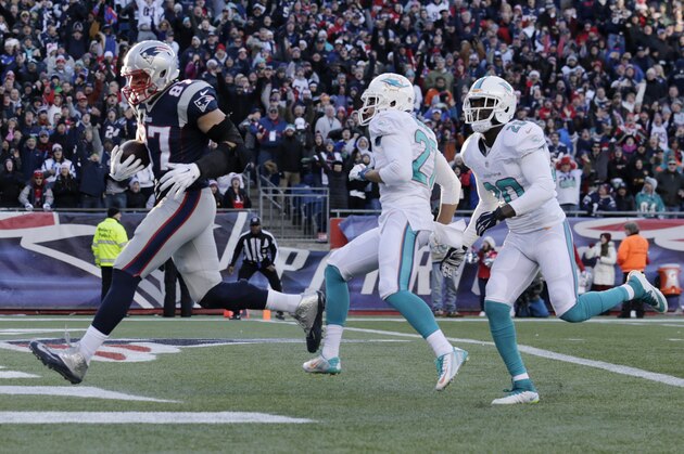 New England Patriots tight end Rob Gronkowski (87) scores a touchdown after catching a pass against the Miami Dolphins in the second half of an NFL football game Sunday, Dec. 14, 2014, in Foxborough, Mass. (AP Photo/Charles Krupa)