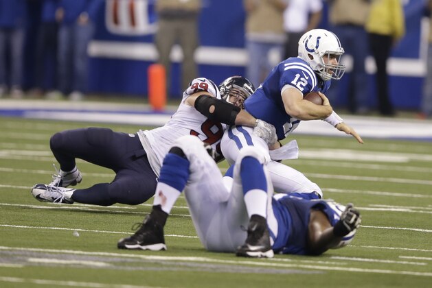 Indianapolis Colts quarterback Andrew Luck, right, is sacked by Houston Texans defensive end J.J. Watt in the first half of an NFL football game in Indianapolis, Sunday, Dec. 14, 2014. (AP Photo/Darron Cummings)