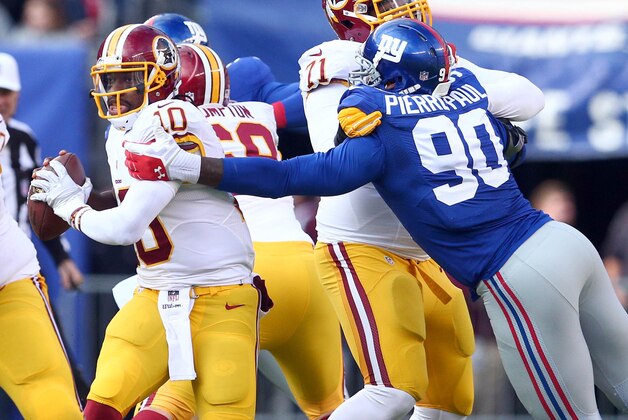 Dec 14, 2014; East Rutherford, NJ, USA; Washington Redskins quarterback Robert Griffin III (10) is wrapped up by New York Giants defensive end Jason Pierre-Paul (90) during the second quarter of a game at MetLife Stadium. Mandatory Credit: Brad Penner-USA TODAY Sports