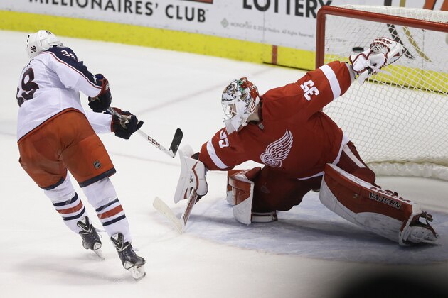Columbus Blue Jackets center Boone Jenner (38) shoots the puck past Detroit Red Wings goalie Jimmy Howard (35) during the shootout period of an NHL hockey game in Detroit, Tuesday, Dec. 16, 2014. The Blue Jackets defeated the Red Wings 1-0. (AP Photo/Carlos Osorio)