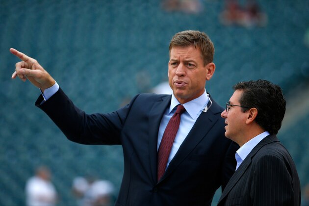 Former quarterback Troy Aikman, left, talks with Washington Redskins owner Dan Snyder before an NFL football game against the Philadelphia Eagles, Sunday, Sept. 21, 2014, in Philadelphia. (AP Photo/Matt Rourke)