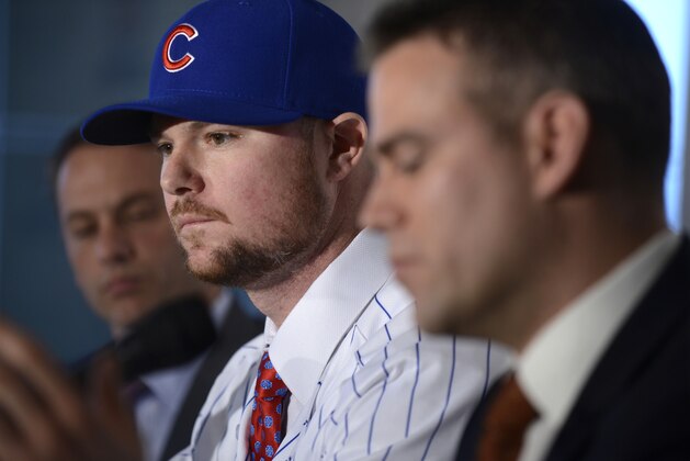 Pitcher Jon Lester center, listens as Chicago Cubs President of Baseball Operations Theo Epstein right, speaks to the media and Vice President of Baseball Operations and General Manager Jeb Hoyer left, looks on after Lester was introduced as a member of the Chicago Cubs during a press conference in Chicago, Monday, Dec. 15, 2014. (AP Photo/Paul Beaty)