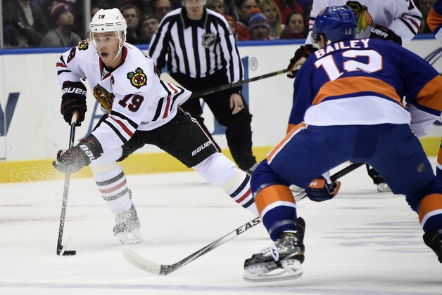 Chicago Blackhawks center Jonathan Toews (19) drives the puck downice past New York Islanders left wing Josh Bailey (12) in the first period of an NHL hockey game on Saturday, Dec. 13, 2014, in Uniondale, N.Y. (AP Photo/Kathy Kmonicek)