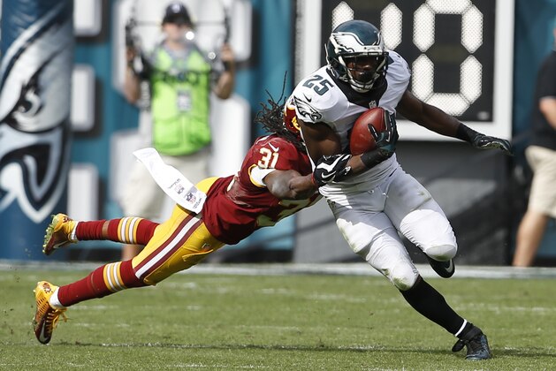 Philadelphia Eagles' LeSean McCoy (25) is tackled by Washington Redskins strong safety Brandon Meriweather (31) during the second half of an NFL football game, Sunday, Sept. 21, 2014, in Philadelphia. (AP Photo/Michael Perez)