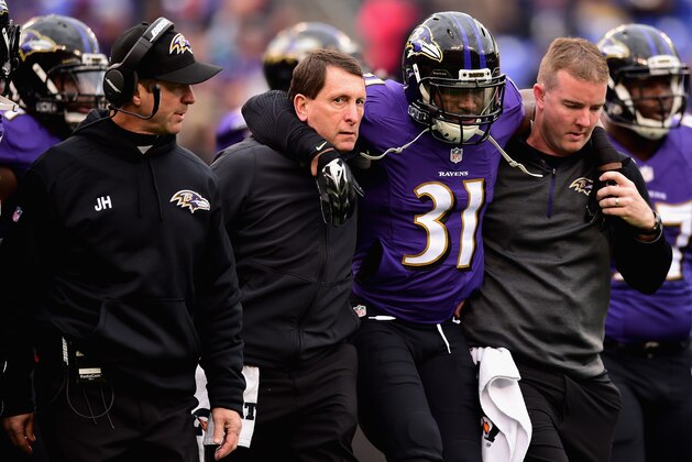 BALTIMORE, MD - DECEMBER 14: Free safety Terrence Brooks #31 of the Baltimore Ravens is helped off the field as head coach John Harbaugh of the Baltimore Ravens looks on during the first quarter of a game against the Jacksonville Jaguars at M&T Bank Stadium on December 14, 2014 in Baltimore, Maryland.  (Photo by Patrick Smith/Getty Images)