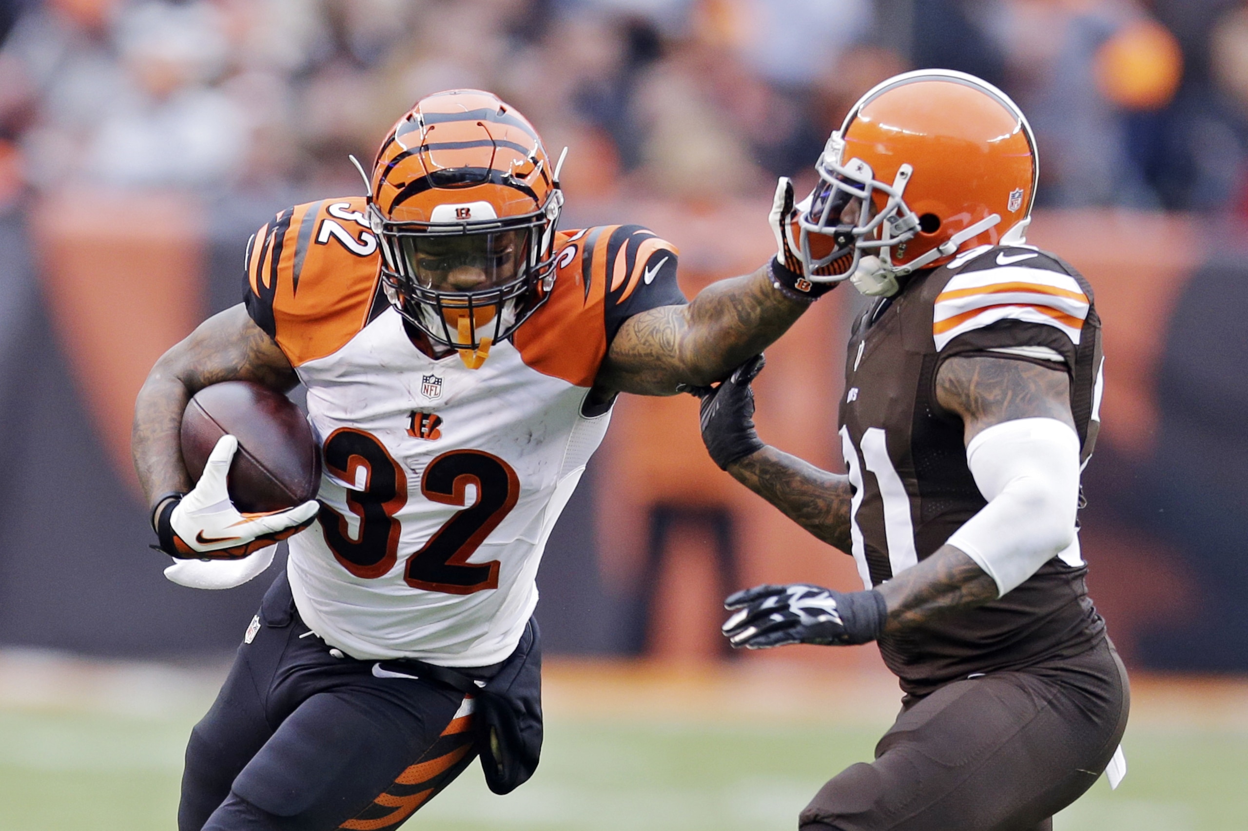 Cincinnati Bengals running back Jeremy Hill (32) runs against Cleveland Browns strong safety Donte Whitner in the second quarter of an NFL football game Sunday, Dec. 14, 2014, in Cleveland. (AP Photo/Tony Dejak)