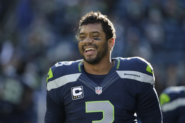 Seattle Seahawks quarterback Russell Wilson smiles before an NFL football game against the San Francisco 49ers, Sunday, Dec. 14, 2014, in Seattle. (AP Photo/Elaine Thompson)