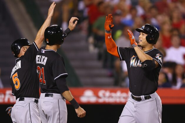 ANAHEIM, CA - AUGUST 25:  Giancarlo Stanton (R) #27 of the Miami Marlins receives high fives from Reed Johnson (L) #5 and Christian Yelich #21 after hitting a three-run home run against the Los Angeles Angels of Anaheim in the fourth inning at Angel Stadium of Anaheim on August 25, 2014 in Anaheim, California.  (Photo by Jeff Gross/Getty Images)