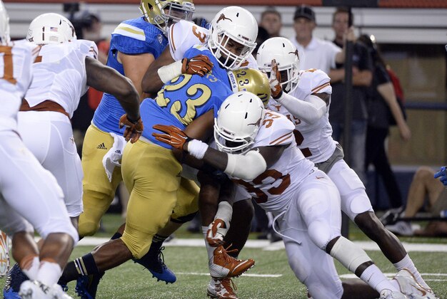 Sep 13, 2014; Arlington, TX, USA; Texas Longhorns linebacker Jordan Hicks (3) and linebacker Steve Edmond (33) tackles UCLA Bruins running back Nate Starks (23) during the second quarter at AT&T Stadium. Mandatory Credit: Richard Mackson-USA TODAY Sports