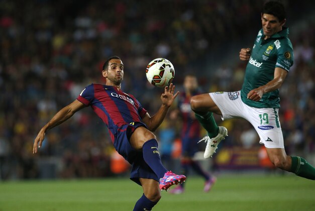 Barcelona's Martin Montoya fights for the ball against Leon's Jonny Magallon during the Joan Gamper trophy friendly soccer match between Barcelona and Leon at the Camp Nou stadium in Barcelona, Spain, Monday, Aug. 18, 2014. (AP Photo/Emilio Morenatti)