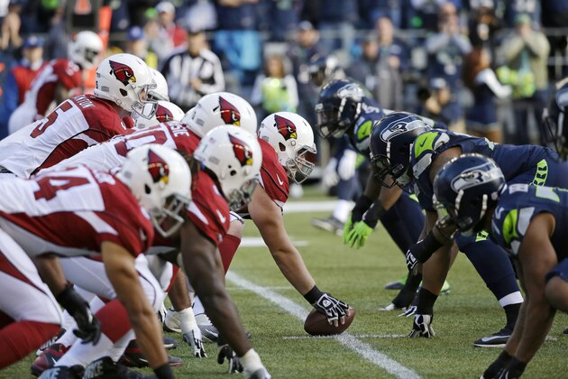 Arizona Cardinals and Seattle Seahawks players line up on the line of scrimmage in the first half of an NFL football game, Sunday, Nov. 23, 2014, in Seattle. (AP Photo/Elaine Thompson)