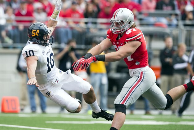 Sep 13, 2014; Columbus, OH, USA; Kent State Golden Flashes quarterback Colin Reardon (10) is knocked to the ground by Ohio State Buckeyes defensive lineman Joey Bosa (97) at Ohio Stadium. Ohio State won the game 66-0. Mandatory Credit: Greg Bartram-USA TODAY Sports