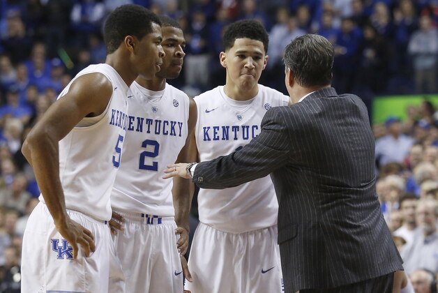 Dec 5, 2014; Lexington, KY, USA; Kentucky Wildcats head coach John Calipari (R) talks with guard Andrew Harrison (5), guard Aaron Harrison (2), and guard Devin Booker (1) during the game against the Texas Longhorns in the second half at Rupp Arena. The Wildcats won 63-51. Mandatory Credit: Mark Zerof-USA TODAY Sports