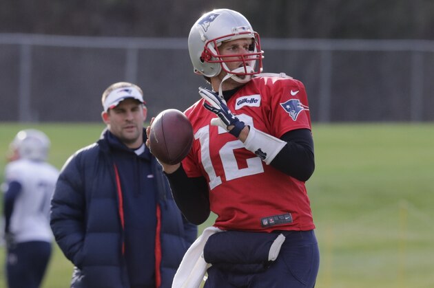 New England Patriots quarterback Tom Brady passes under the watchful eye of offensive coordinator Josh McDaniels, right, during an NFL football practice in Foxborough, Mass., Wednesday, Dec. 17, 2014. (AP Photo/Charles Krupa)