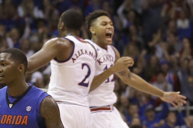 Florida forward Dorian Finney-Smith (10) walks off the floor while Kansas forward Cliff Alexander (2) and guard Kelly Oubre Jr. (12) celebrate during a timeout in the second half of an NCAA college basketball game in Lawrence, Kan., Friday, Dec. 5, 2014. Kansas defeated Florida 71-65. (AP Photo/Orlin Wagner)